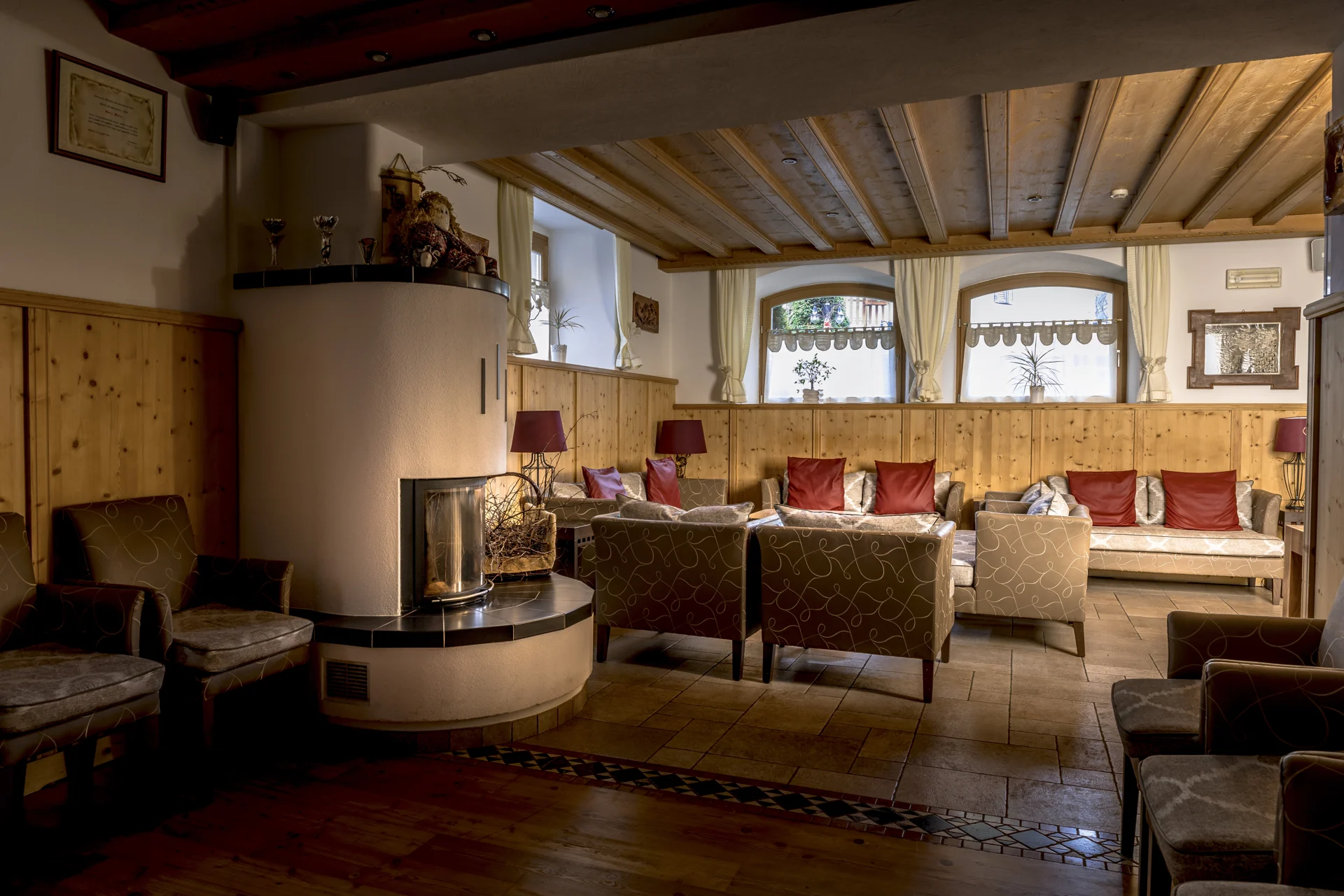 Salotto dell’Hotel Paganella con camino e arredi in legno